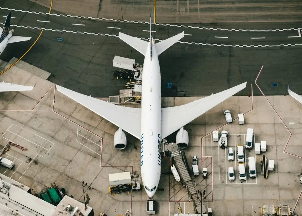 White and blue airplane on the apron in daylight